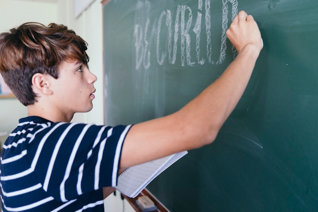 Foto gratuita alumno de perfil escribiendo en la pizarra