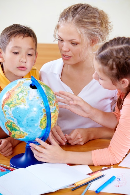 Alumnos mirando el globo mientras escuchan a la maestra