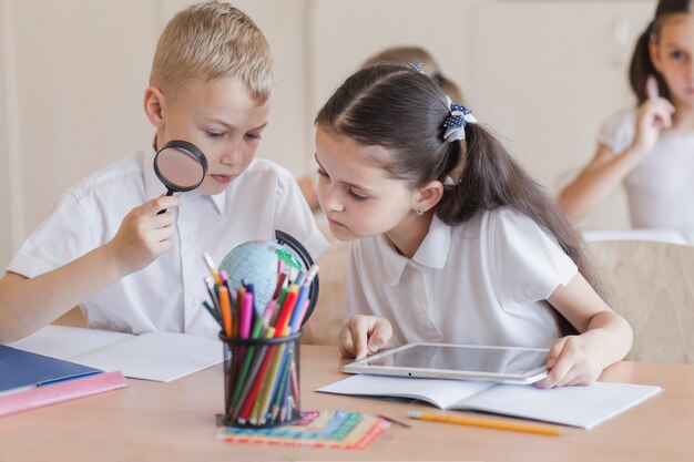 Alumnos que examinan el mundo en la lección