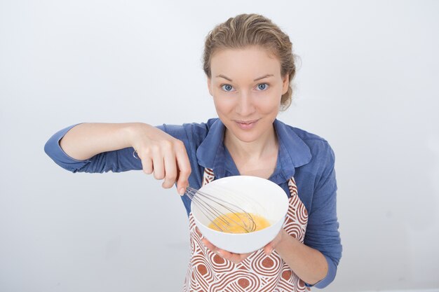 Ama de casa joven satisfecho que muestra cómo cocinar