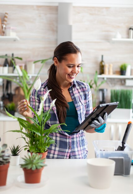 Ama de casa leyendo sobre el suelo para las flores durante la jardinería en casa