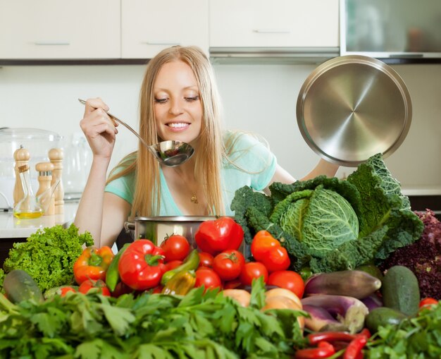 Ama de casa de pelo largo que cocina con verduras frescas