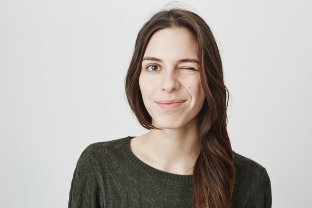 Amable mujer sonriente dar guiño alentador