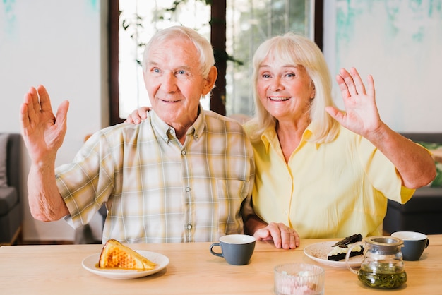 Foto gratuita amable pareja de ancianos saludando con las manos