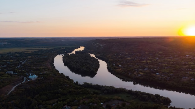 Amanecer en Moldavia, aldea con iglesia ortodoxa, río dividido en dos partes