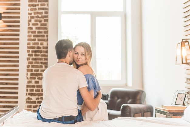 Foto gratuita amante joven pareja sentada en la cama