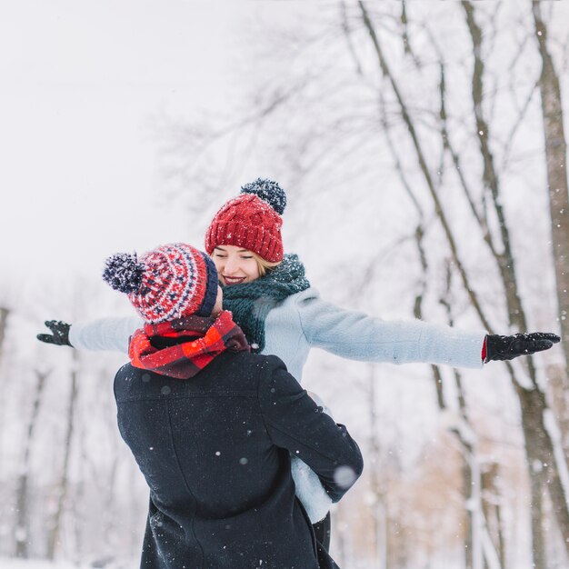 Amantes de la joven pareja en las nevadas de invierno