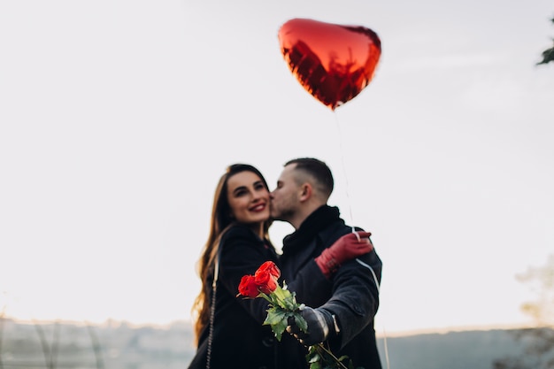 Foto gratuita amantes jóvenes con rosas y globos