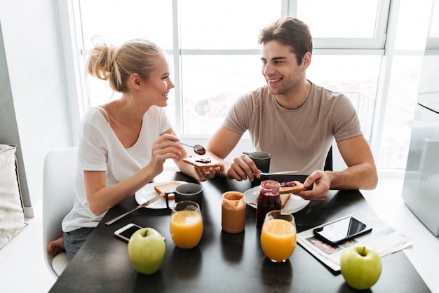 Foto gratuita amantes sanos sentados en la cocina y desayunando