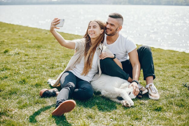 amantes tiernos y felices están pasando un buen rato en el lago con perro