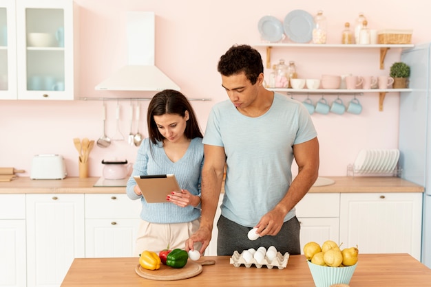 Amantes de tiro medio cocinando juntos