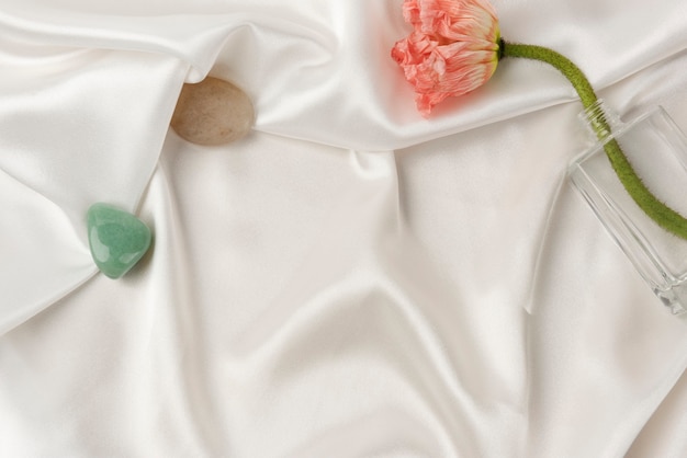 Amapola clavel en un jarrón sobre fondo de textura de tela blanca