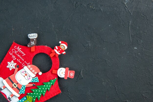 Ambiente navideño con accesorios de decoración y caja de regalo de año nuevo en el lado derecho sobre una superficie oscura