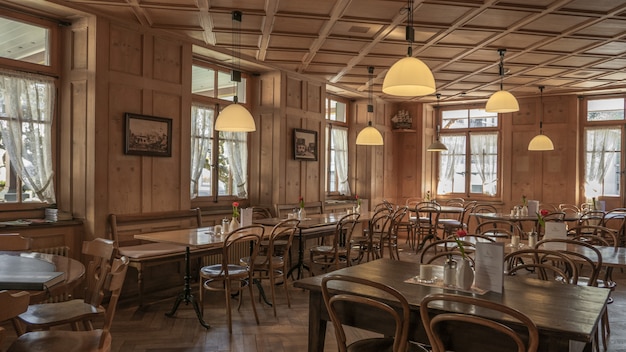 Ambiente de restaurante con sillas y mesas de madera y una hermosa vista