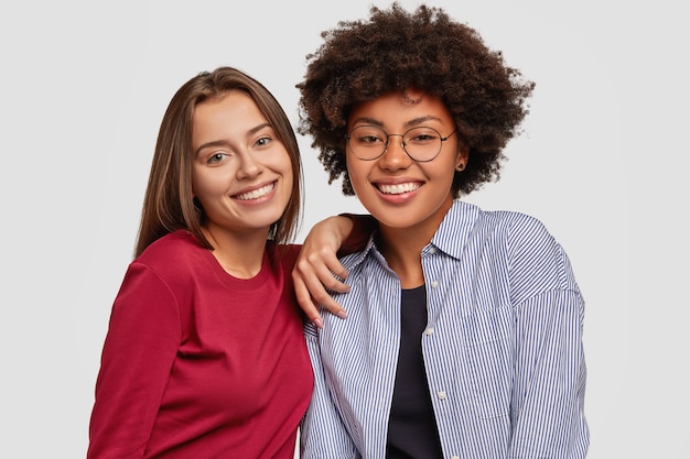 Amigables chicas multiétnicas se divierten juntas, se regocijan en un día exitoso en el trabajo