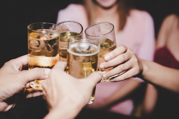 Amigas con cerveza de cristal en una fiesta