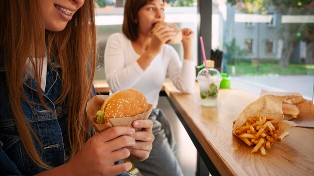 Amigas comiendo hamburguesa juntos