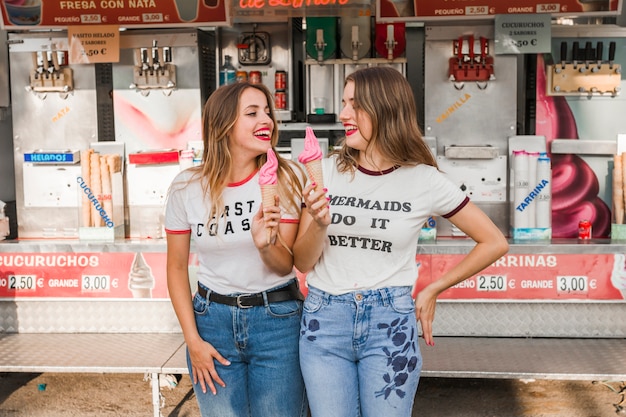 Amigas comiendo un helado en el parque de atracciones