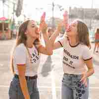 Foto gratuita amigas comiendo un helado en el parque de atracciones