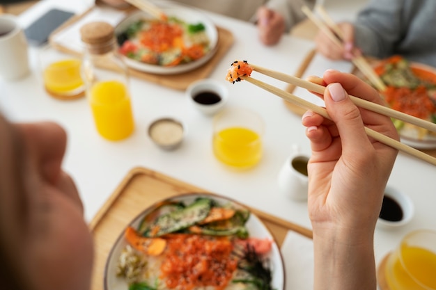 Amigas comiendo platos de mariscos con salmón juntos