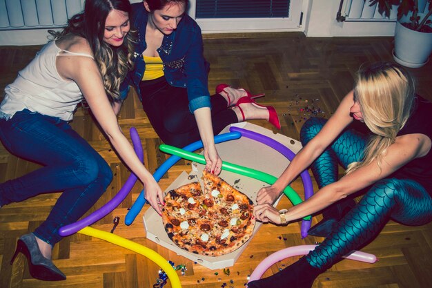 Amigas compartiendo pizza