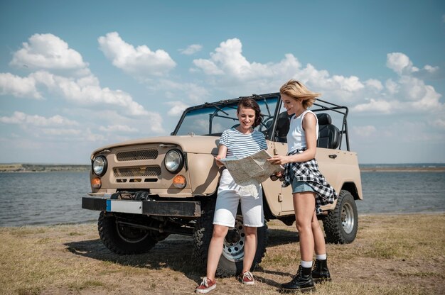 Amigas comprobando el mapa mientras viaja en coche