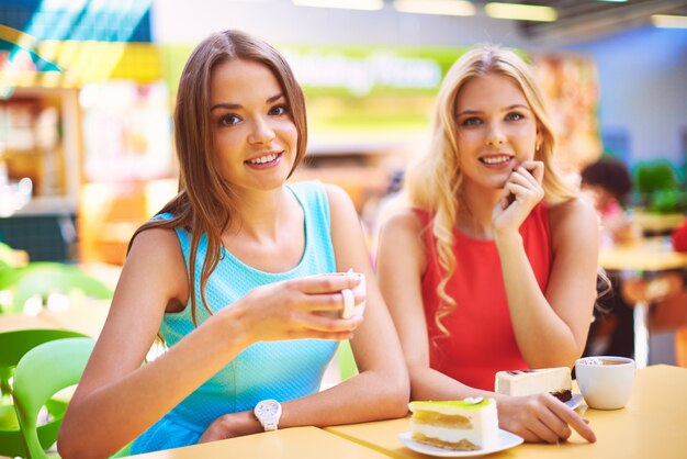 Amigas disfrutando de una taza de té y un trozo de pastel