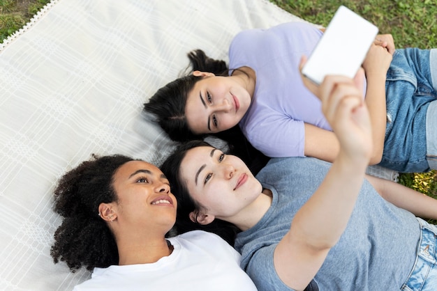 Amigas divirtiéndose en el parque mientras toma selfie