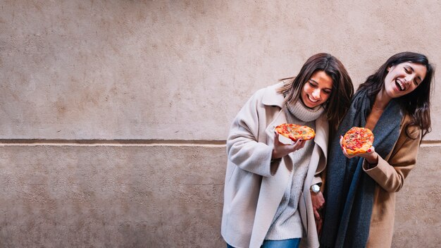 Amigas emocionales riendo y abrazar en la calle