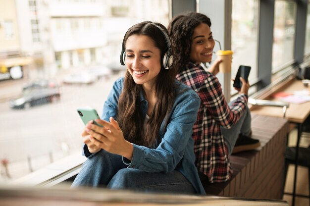 Amigas escuchando música con auriculares