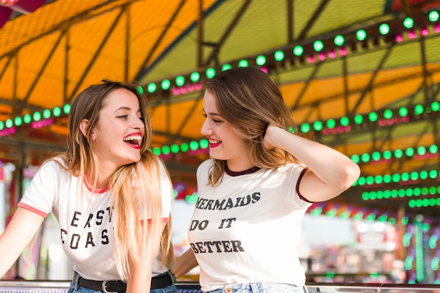 Amigas felices divirtiéndose en el parque de atracciones