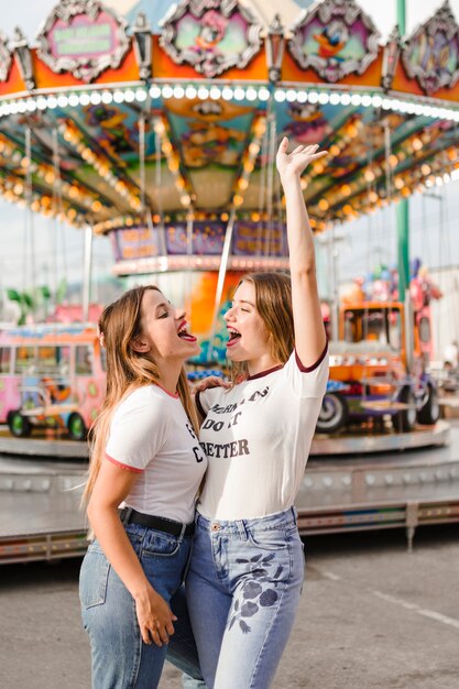 Amigas felices divirtiéndose en el parque de atracciones