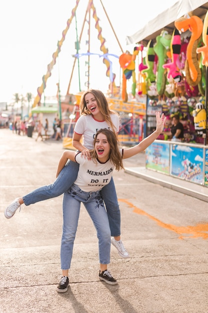 Amigas felices divirtiéndose en el parque de atracciones