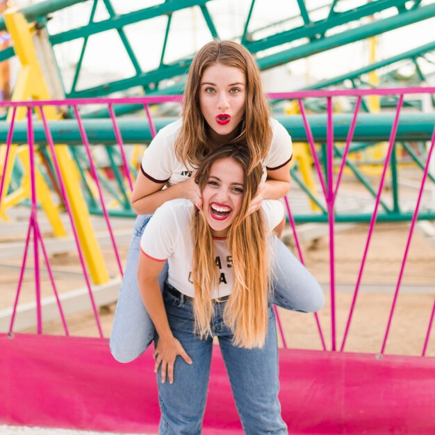 Amigas felices divirtiéndose en el parque de atracciones