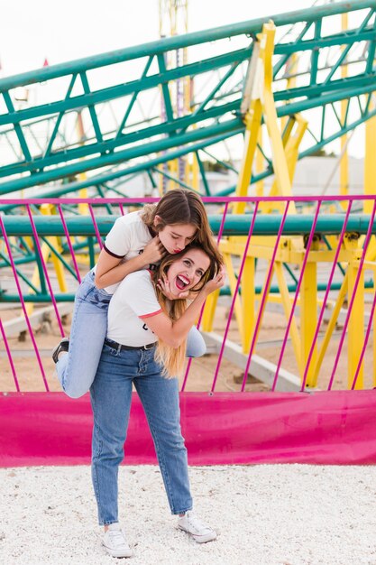 Amigas felices divirtiéndose en el parque de atracciones