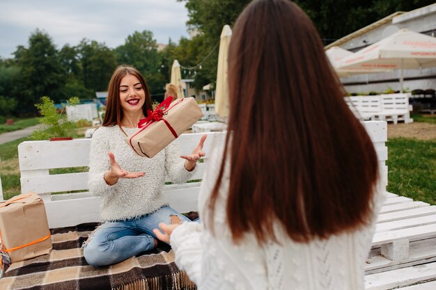 Amigas felices jugando con un regalo envuelto