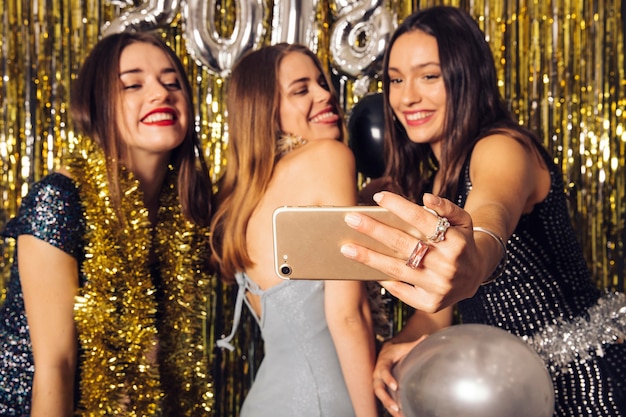 Amigas haciendo un selfie en celebración de año nuevo