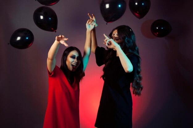 Amigas de halloween teniendo una fiesta con globos