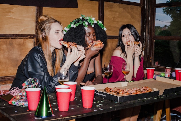 Foto gratuita amigas hambrientas comiendo pizza