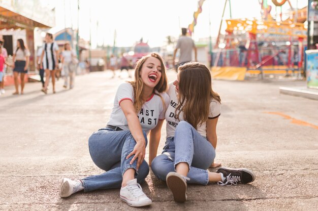 Amigas jóvenes felices en el parque de atracciones