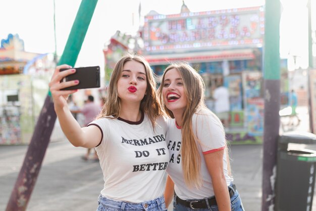 Amigas jóvenes felices en el parque de atracciones