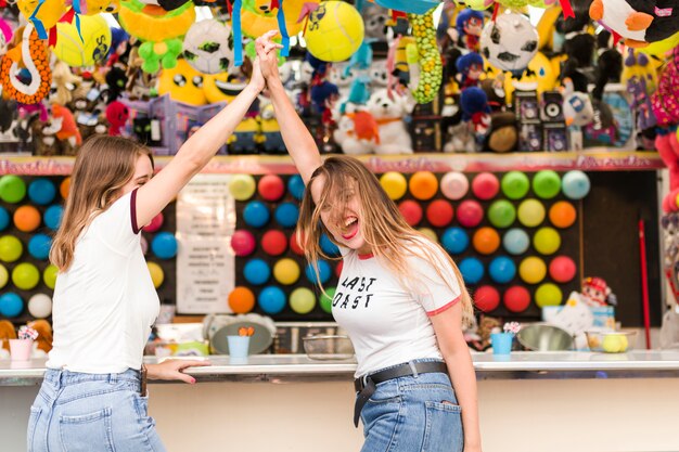 Amigas jóvenes felices en el parque de atracciones