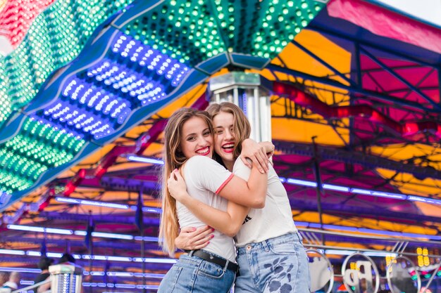 Amigas jóvenes felices en el parque de atracciones