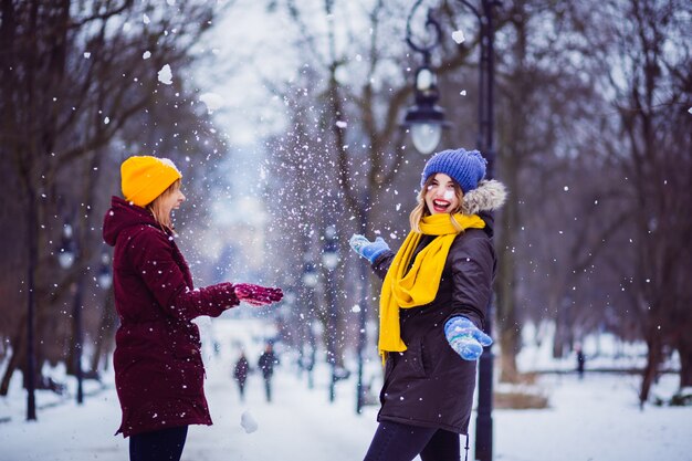 Las amigas jugando con la nieve en el parque