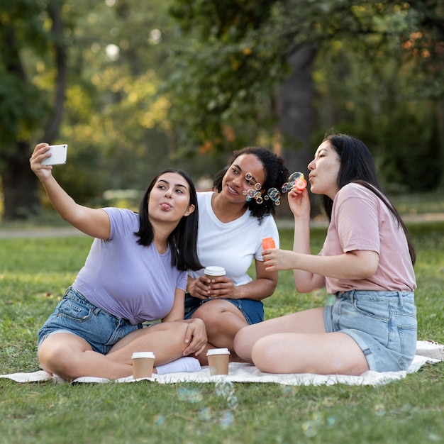 Amigas juntas en el parque tomando selfie