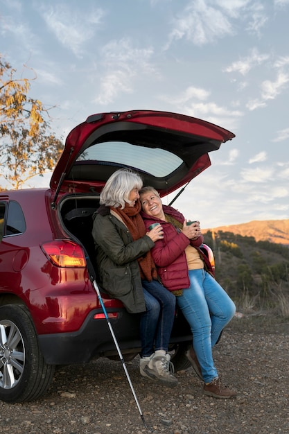 Amigas mayores en una aventura desde el maletero de su coche