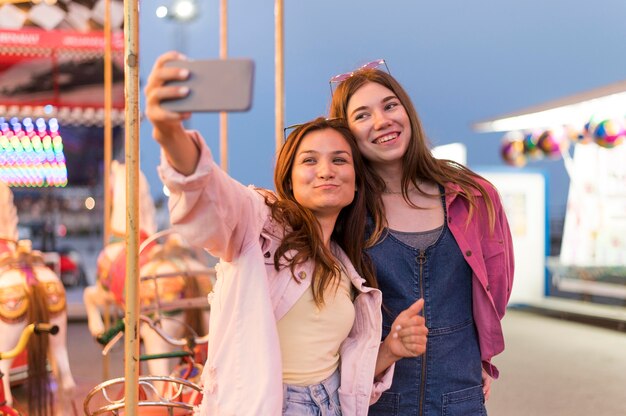 Amigas en el parque de atracciones tomando selfie