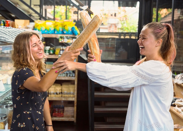 Amigas peleando con baguettes de pan