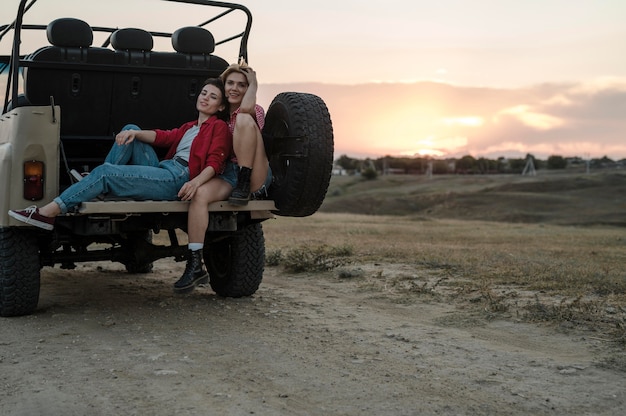 Amigas posando juntos mientras viaja en coche