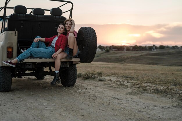 Amigas posando juntos mientras viaja en coche